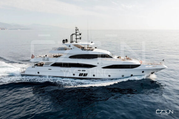 A luxury yacht cruising the clear blue waters near Bodrum, Turkey, with scenic coastline and iconic white houses in the background.