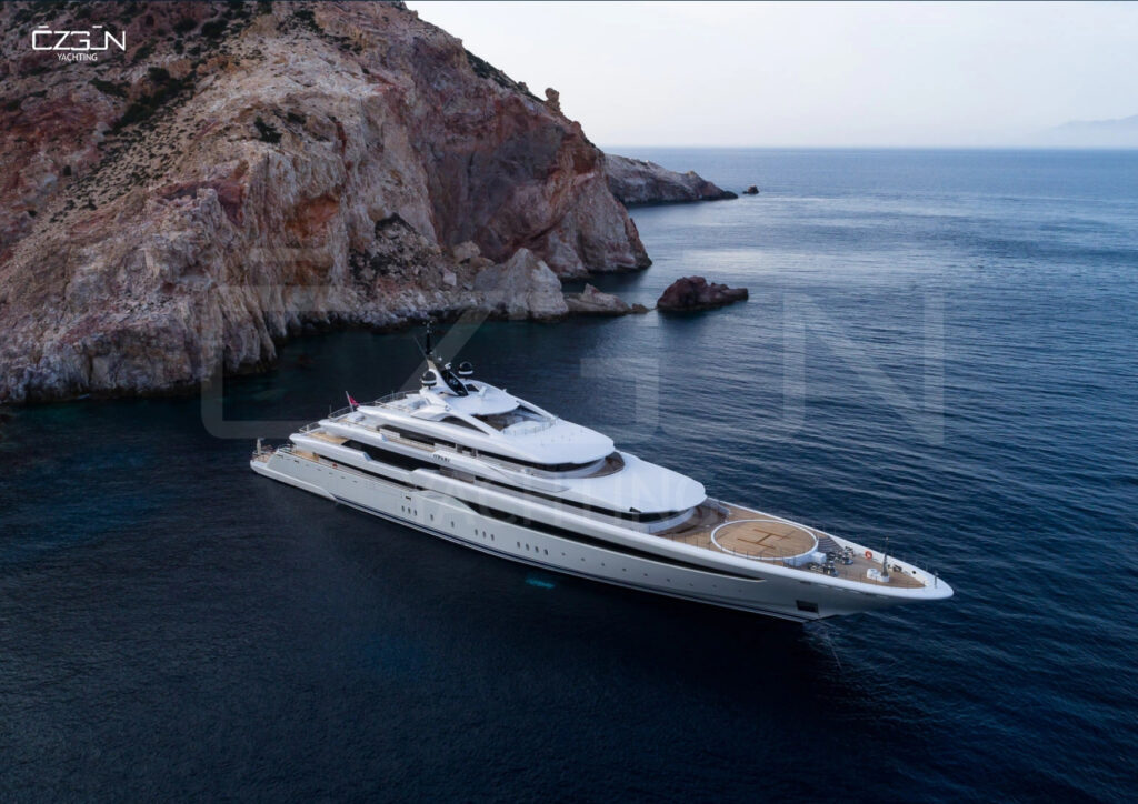A luxurious yacht anchored in a serene Greek bay, part of a private charter with Özgün Yachting.